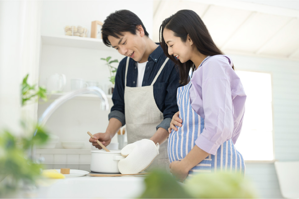 料理を一緒にしている男女（妊婦）