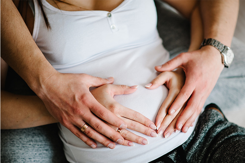 お腹に手を添える妊婦さんとパートナー