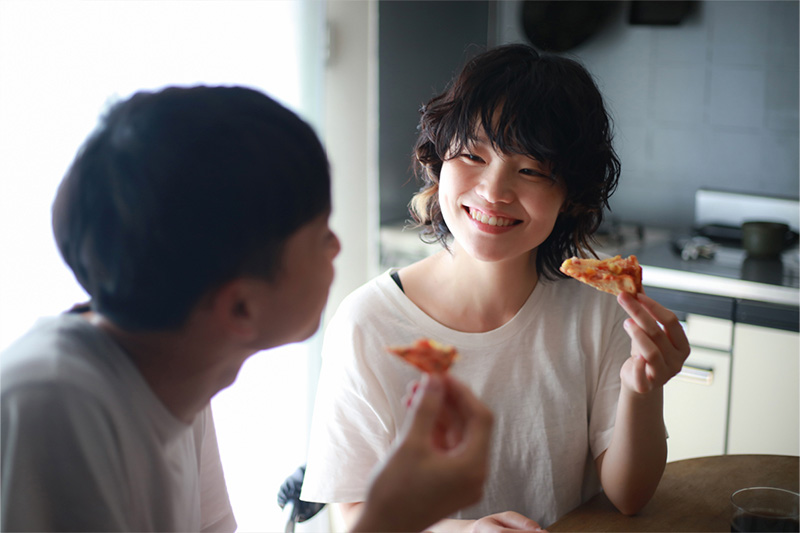 ピザを食べるママとパパ