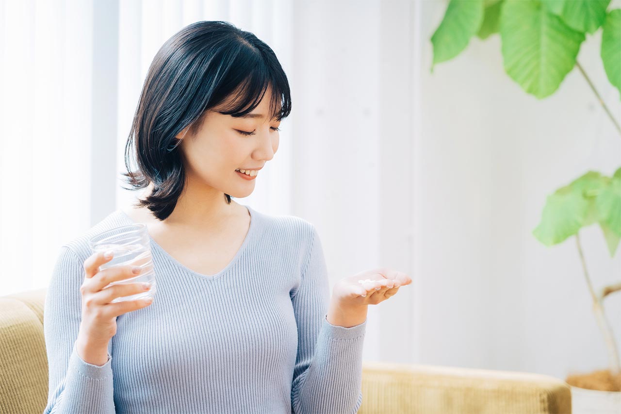 サプリと水を持つ女性